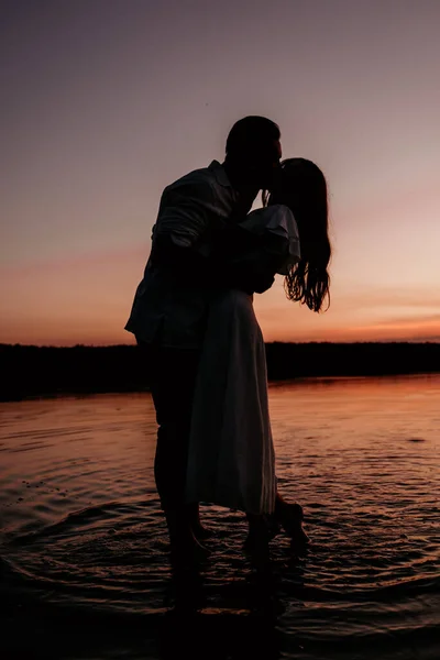 Casal Jovem Abraçando Beijando Água Pôr Sol Duas Silhuetas Contra — Fotografia de Stock