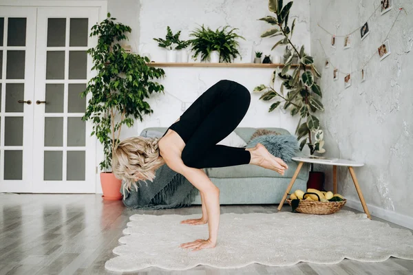 Giovane donna bionda che pratica yoga a casa . — Foto Stock