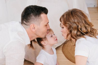 Sevimli kız ve baba gıdıklıyor anne evde birlikte oynayarak iyi vakit geçiriyor mutlu ebeveynler ve küçük kız çocuk eğlenceli aktivitelerin ve iletişimin tadını çıkarıyor aile gülüşleri rahatlatıcı