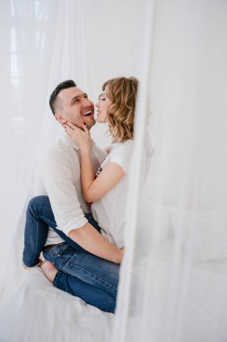 Genç çift portresi. Güzel, güzel bir kadın yakışıklı bir adamı öpüyor. Duygusal fotoğraf.