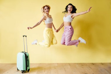 Esmer ve sarı arka planda renkli pantolonlu sarışın. Pembe ve sarı renk. Nane bavulu ve ananasla seyahat etmek..