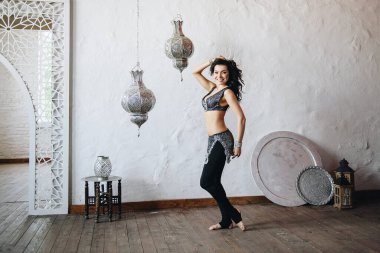 Göbek dansı kostümü. Doğu dansı için kostüm. Doğu yakası. Doğu görünümlü güzel bir kız. Koyu uzun saçlı. Dersler, egzersizler. Dansta hareket var. Bedleh ya da Beledi. Arap dansı