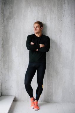 Evde idman yapıyorum. Eşofmanlı adam. Siyah spor üniforması. Erkek sporcu. Vücudu şişmiş. Triatlon. Sabah sporu. Vücut için bir takım egzersizler.