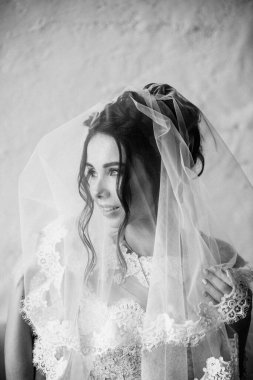 Güzel bir gelinin portresi. Sabahları evde şarj oluyor. Klasik bir düğün. Peçeyi yüzüne kapadı. Siyah beyaz fotoğraf