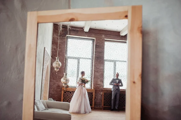 穿着粉红衣服的新娘和穿着灰色西服的新郎 镜中的倒影 摩洛哥风格的房间 — 图库照片