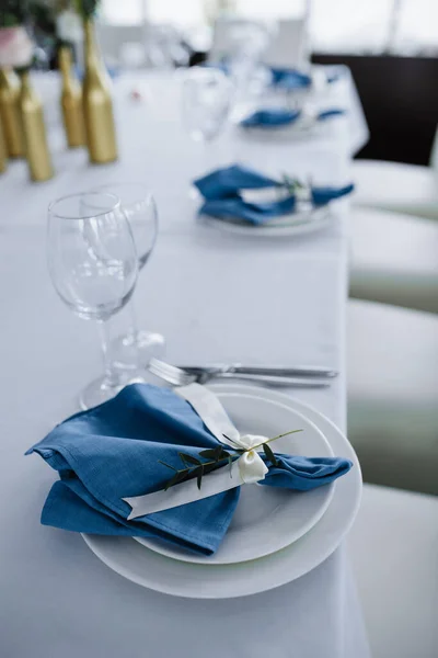 Served for wedding banquet table in blue white. Wedding decoration. Blue napkin with flower on a white plate.