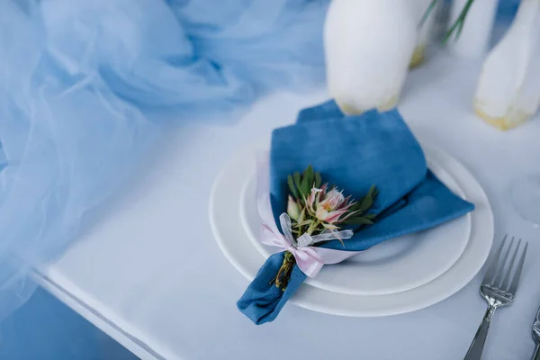 Served for wedding banquet table in blue white. Wedding decoration. Blue napkin with flower on a white plate.