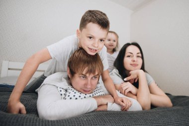 Evde pijamalı bir aile. Kızı ve oğlu. Sabah uyanırsın. Yatak odasında sarılıp öpüşüyorlar..