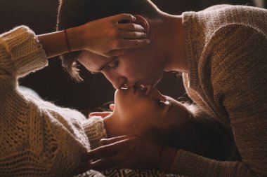 Yatak odasındaki yatakta bir çift. İçi karanlık. Yeni yıl ve Noel. Öpücükler ve sarılmalar. Sevgi. Beyaz kazak ve yüksek çoraplar. Romantik bir buluşma. Randevu aşıkları..