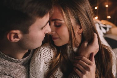 Yatak odasındaki yatakta bir çift. İçi karanlık. Yeni yıl ve Noel. Öpücükler ve sarılmalar. Sevgi. Beyaz kazak ve yüksek çoraplar. Romantik bir buluşma. Randevu aşıkları..