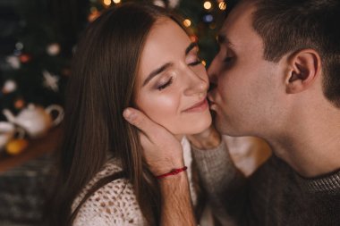 Yatak odasındaki yatakta bir çift. İçi karanlık. Yeni yıl ve Noel. Öpücükler ve sarılmalar. Sevgi. Beyaz kazak ve yüksek çoraplar. Romantik bir buluşma. Randevu aşıkları..