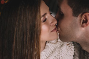 Yatak odasındaki yatakta bir çift. İçi karanlık. Öpücükler ve sarılmalar. Aşık ol. Beyaz kazak ve yüksek çoraplar. Romantik bir buluşma. Randevu aşıkları. Şefkat.