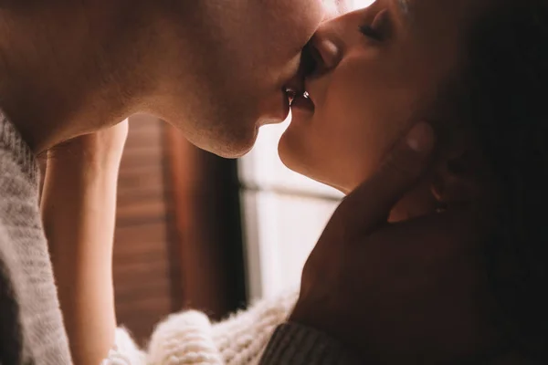 Couple near the window. Hugs and kisses. Be in love. White sweater and high socks. Romantic meeting. A date lovers. Tenderness.