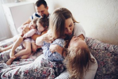 Çocuklar ve ebeveynler sabahları yatakta dinlenirler. Çocuklar şımarır, sarılırlar. İkizler. Ağaç kızları.