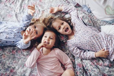 Üç kız kardeş yan yana yatar