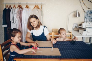 Anne ve kızları birbirine elbise dikerler. Model elbisesi. Anne ve kızları birbirine kıyafet dikerler. Kalıp elbise..
