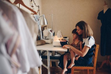 Anne ve kızı birbirine elbise dikiyor. Şablon elbisesi. Elektrik Dikiş Makinesi