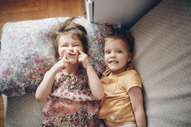 İki kız kardeş yan yana yatar