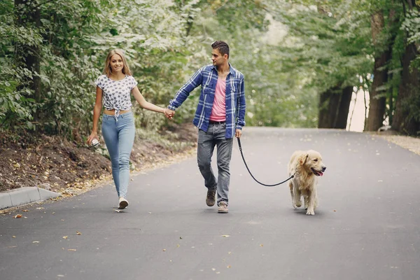 Casal andando ao ar livre com seu cão — Fotografia de Stock