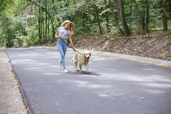 Paar geht mit Hund im Freien spazieren — Stockfoto