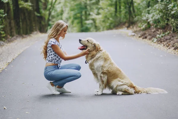 Пара, гуляющая на улице с собакой — стоковое фото
