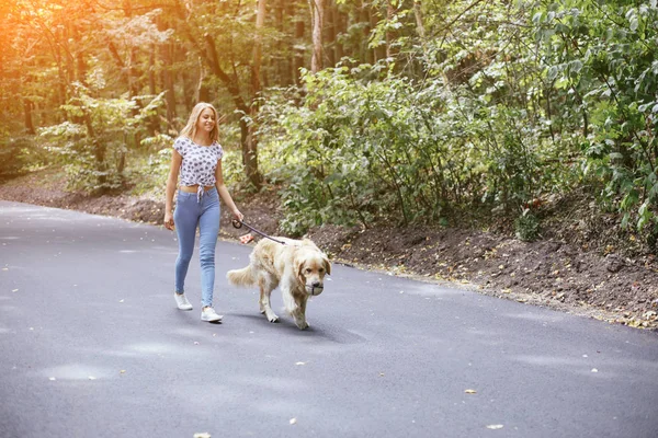 Paar geht mit Hund im Freien spazieren — Stockfoto