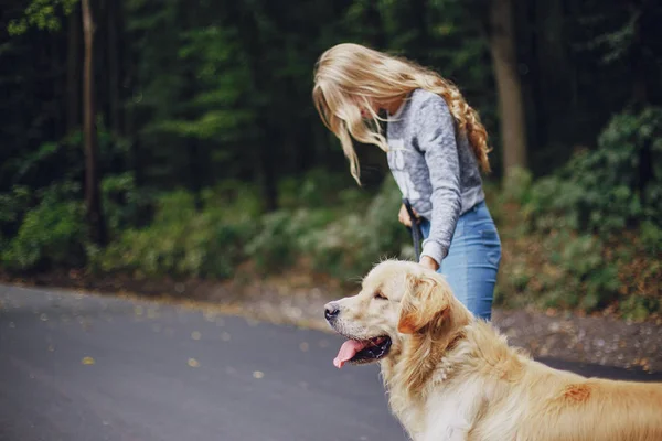 Paar geht mit Hund im Freien spazieren — Stockfoto