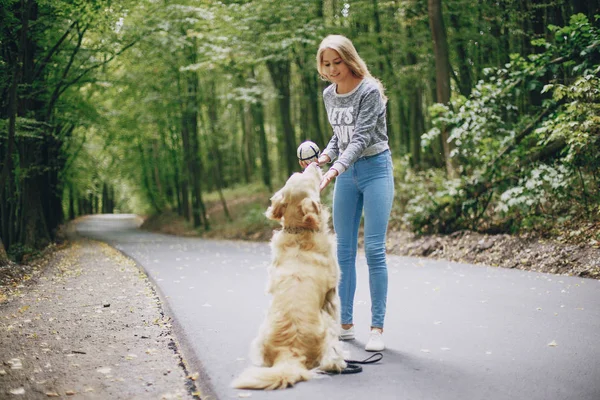 Paar geht mit Hund im Freien spazieren — Stockfoto