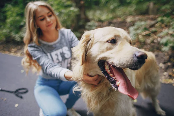 Casal andando ao ar livre com seu cão — Fotografia de Stock