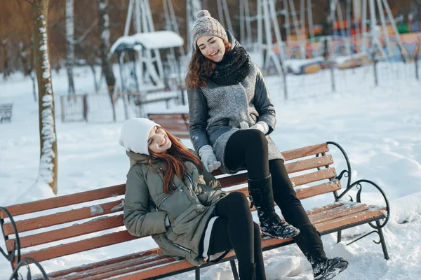 Las niñas se sientan en un banco — Foto de Stock