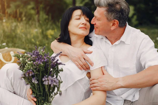 Beautiful adult couple spend time in a summer field