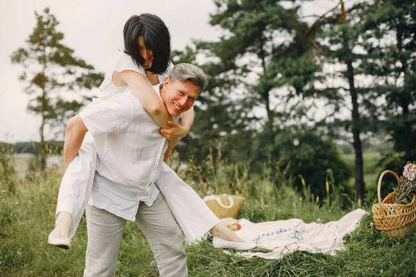 美丽的一对成年夫妇在夏天的田野里消磨时间 — 图库照片