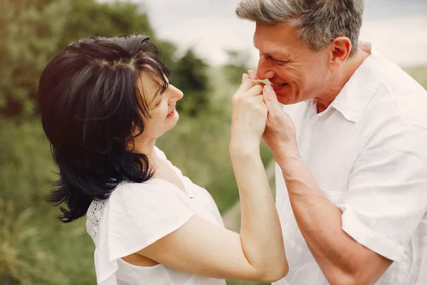 Güzel yetişkin bir çift yaz tarlasında vakit geçirir.