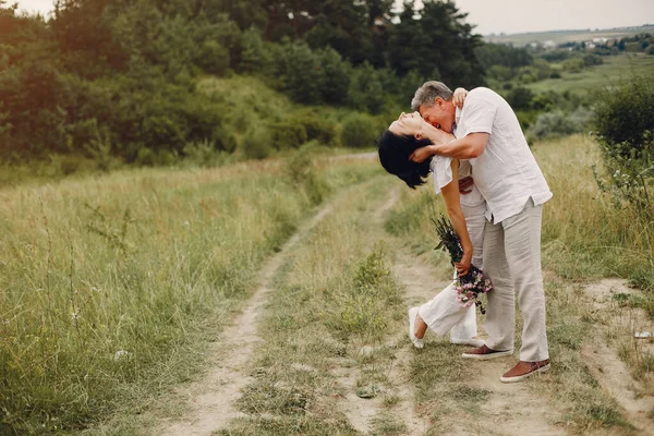 美しい大人のカップルは夏のフィールドで時間を過ごす — ストック写真