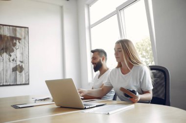 Birlikte çalışan gençler dizüstü bilgisayarlarını kullanıyorlar.