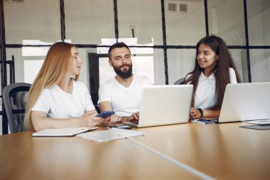 Genç ekip birlikte çalışıyor ve bilgisayarı kullanıyor.