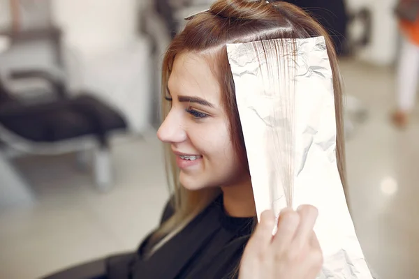 Fryzjer kolorowe włosy jej klienta w salonie fryzjerskim — Zdjęcie stockowe