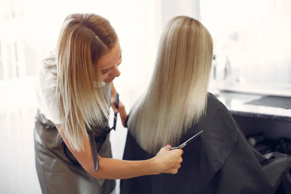 Hairdresser cut hair her client in a hair salon — ストック写真