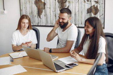 Genç ekip birlikte çalışıyor ve bilgisayarı kullanıyor.