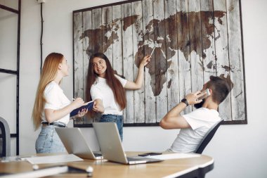 Genç ekip birlikte çalışıyor ve bilgisayarı kullanıyor.