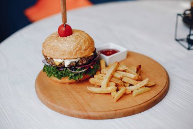 Bir kafede masada hamburger ve patates kızartması.