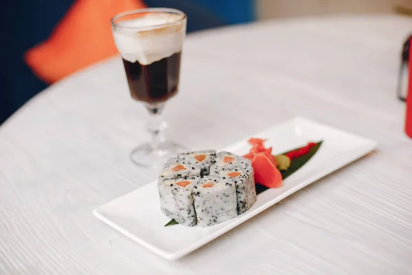 Sushi dan segelas kopi di atas meja putih — Stok Foto