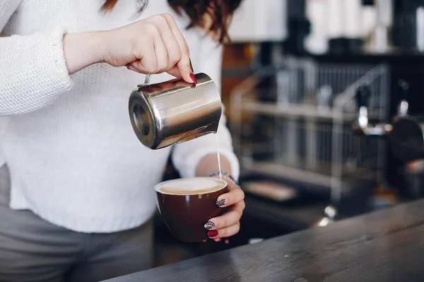 Overhead άποψη θηλυκό barista ρίχνει αφρό γάλακτος σε καπουτσίνο στο καφέ — Φωτογραφία Αρχείου