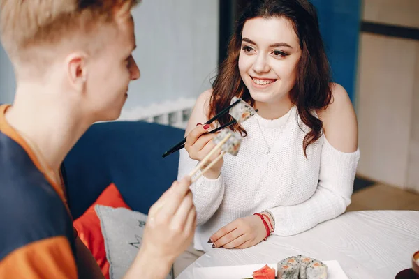 Casal sentado em um café e comer sushi — Fotografia de Stock