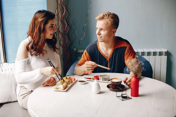 Para siedząca w kawiarni i jedząca sushi — Zdjęcie stockowe