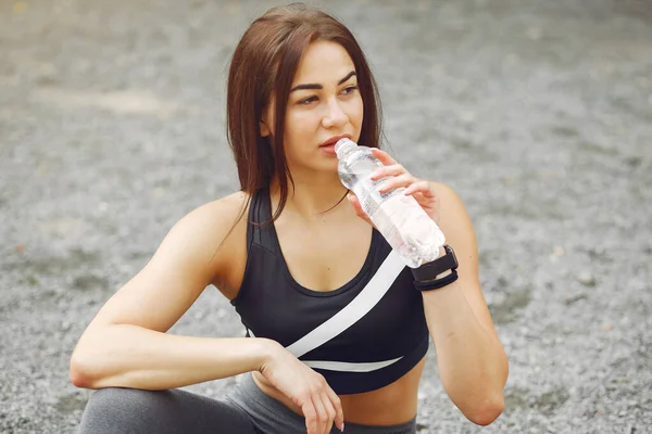 Chica deportiva en una ropa deportiva bebiendo agua —  Fotos de Stock