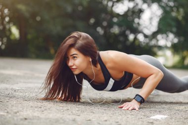 Yaz parkında kulaklıkla spor kız eğitimi.