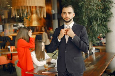 Ortaklar masada oturuyor ve bir kafede çalışıyor.