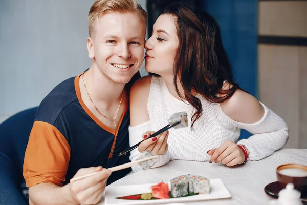 Couple assis dans une caffe et manger des sushis — Photo