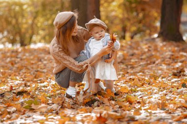 Sonbahar parkında şirin ve şık bir aile.